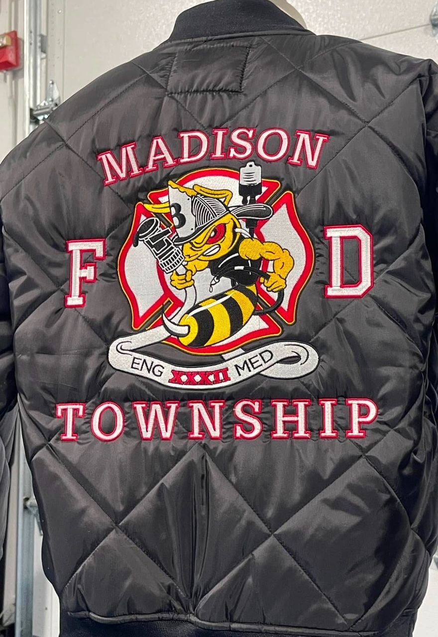 Black quilted jacket with a large embroidered Madison Township fire department back design