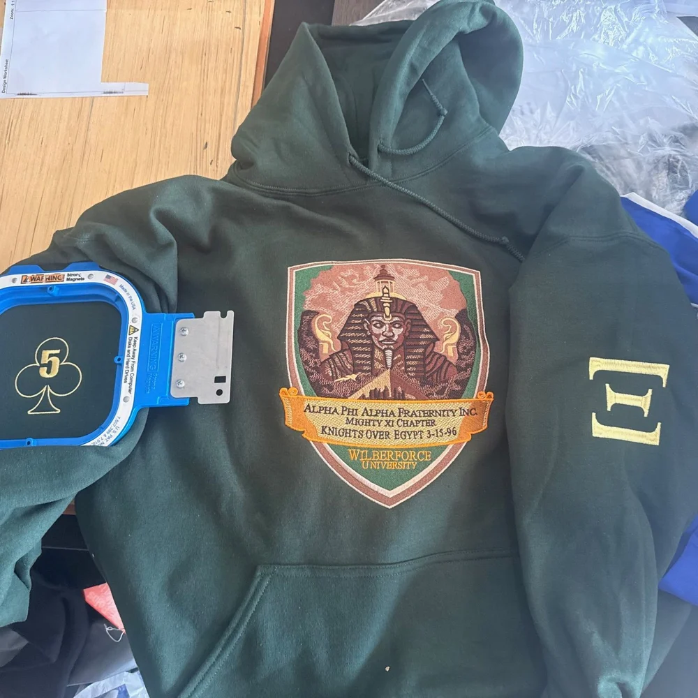 Green hoodie with pharaoh artwork and embroidered sleeve details