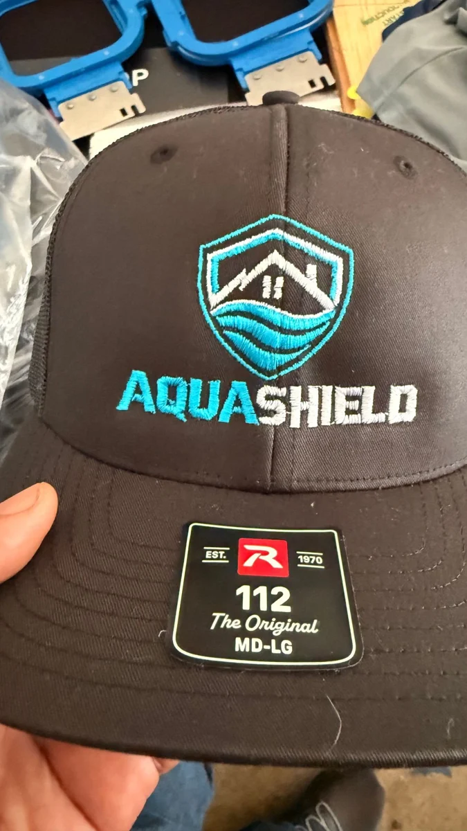 AquaShield logo embroidered on a black cap